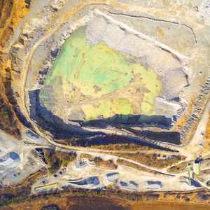 泥泞施工现场或露天矿山推土机的鸟瞰图。 重工业从上面。 来自满目疮痍的景观的工业背景。